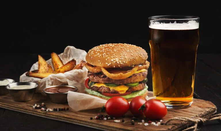 Hamburger made of beef and beer on wooden cutting board Hamburger made of beef and beer on wooden cutting board